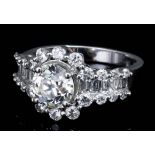 A modern silvery coloured metal mounted diamond ring, central oval brilliant cut diamond of