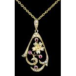 An Edwardian 15ct gold seed pearl and garnet set pendant, of scrolling form the seed pearl set