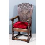 An old panelled oak Wainscot armchair of "17th Century" design, the panelled back with shaped