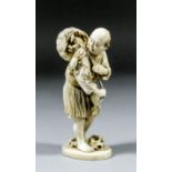 A Japanese carved ivory okimono of a standing fisherman carrying a basket of crabs on his back,