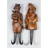 Two Black Forest carved wood coat hooks, wolf with tankard and dog with rifle, each 12ins high