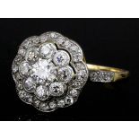 A modern gold coloured metal mounted all diamond set flower head pattern ring, the face set with
