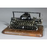 A Blickensderfer "Model Seven" typewriter, on oak base, 13.25ins x 11ins, and cover for same (