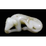 A Chinese pale celadon jade carving of a reclining dog, 3.375ins (8.5cm) overall x 1ins (2.5cm)