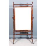 A George IV mahogany framed cheval mirror with turned framing and turned finials, on moulded splay