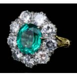 A modern 18ct gold mounted emerald and diamond ring, oval cut emerald of 2.64ct surrounded by nine