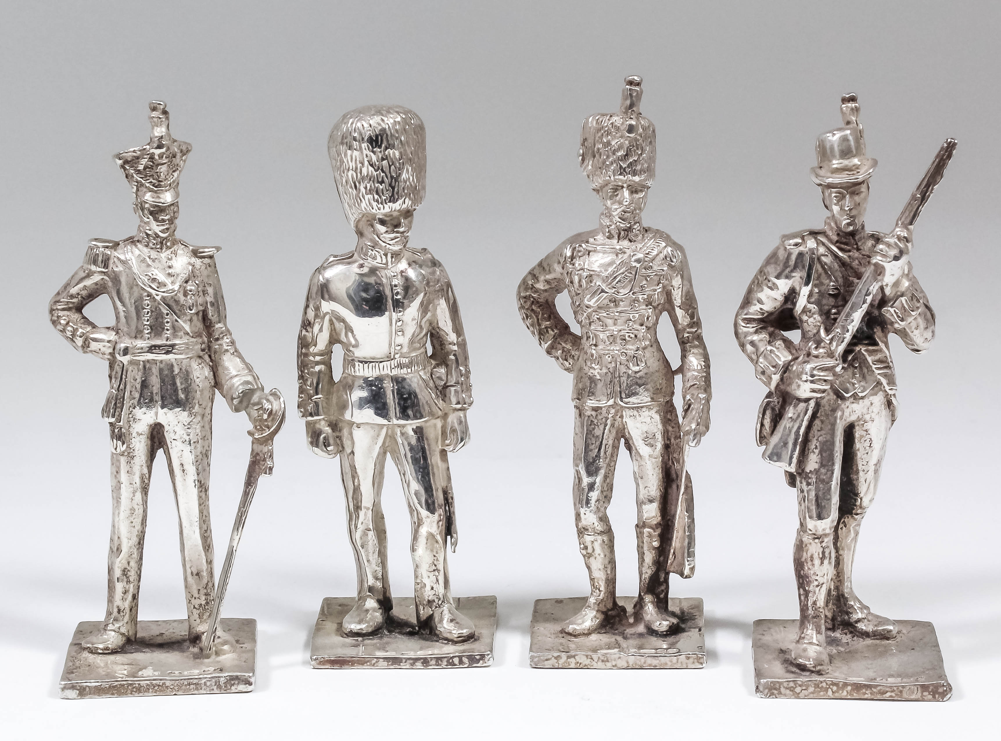 Four Elizabeth II cast silver models of soldiers in uniform (various regiments), 4ins and 4.25ins