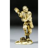 A Japanese carved and stained ivory okimono of a standing fisherman, his right hand raised with a