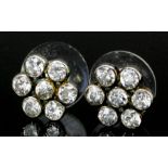 A pair of silvery coloured metal mounted all diamond set flower head earrings (for pierced ears),