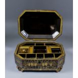 A Chinese black lacquer octagonal workbox decorated in gilt with chinoiseries landscapes, the