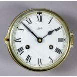 A 20th Century brass cased ships bulkhead clock by Scharatz, the 5.75ins diameter painted metal dial