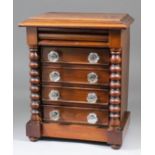 A late Victorian mahogany miniature chest of five drawers, the top drawer with shaped front, flanked