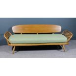 A modern Ercol elm and beech studio settee designed by Lucian Ercolani (1888-1976), with propeller