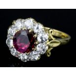 A modern 18ct gold mounted ruby and diamond ring, the circular cut ruby of 0.99ct bordered by ten