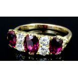 A modern gold coloured metal mounted ruby and diamond ring, the three oval cut rubies interspersed