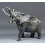 A Beswick pottery figure of an elephant, 10.25ins high (left tusk restored)