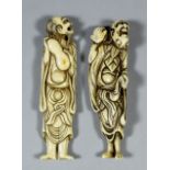 Two Japanese carved ivory elongated netsukes of a standing man holding a double gourd, 4.5ins (11.