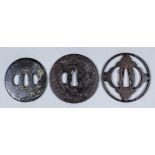 Three Japanese cast iron tsuba, one pierced with plum and cherry blossom, one carved with a shi