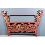 A Chinese red lacquer and gilt decorated headboard, fretted and carved with dragons, exotic birds