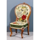 A Victorian walnut framed spoon back nursing chair, the showwood frame with floral carved