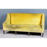 A George III square and wing back three seat settee upholstered in old gold velour and brass