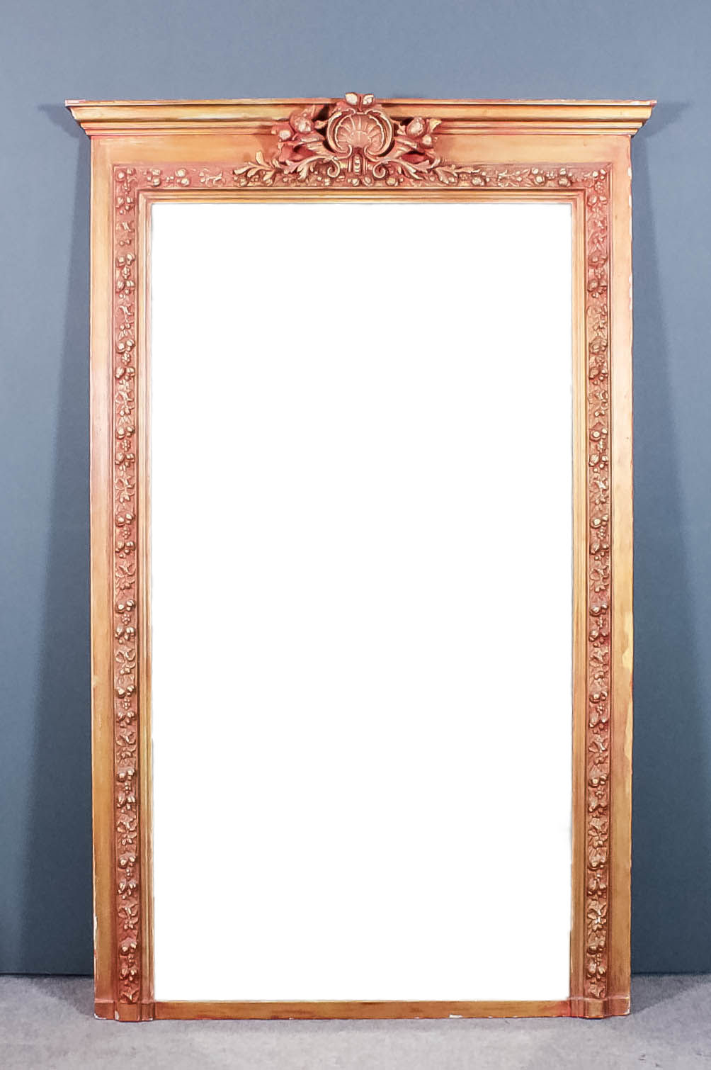 A Continental red painted and gilt framed rectangular overmantel mirror with moulded cornice, the