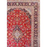 A Tabriz carpet woven in colours with a central medallion and conforming spandrels, floral filled