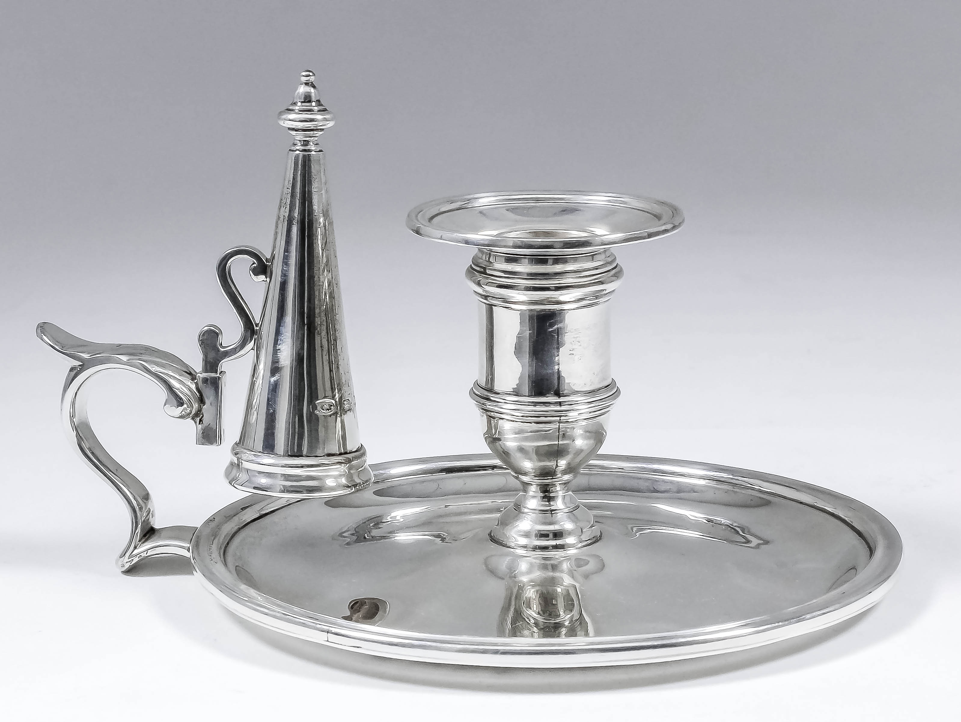 An Elizabeth II plain cast silver circular chamber candlestick of "Georgian" design, with moulded