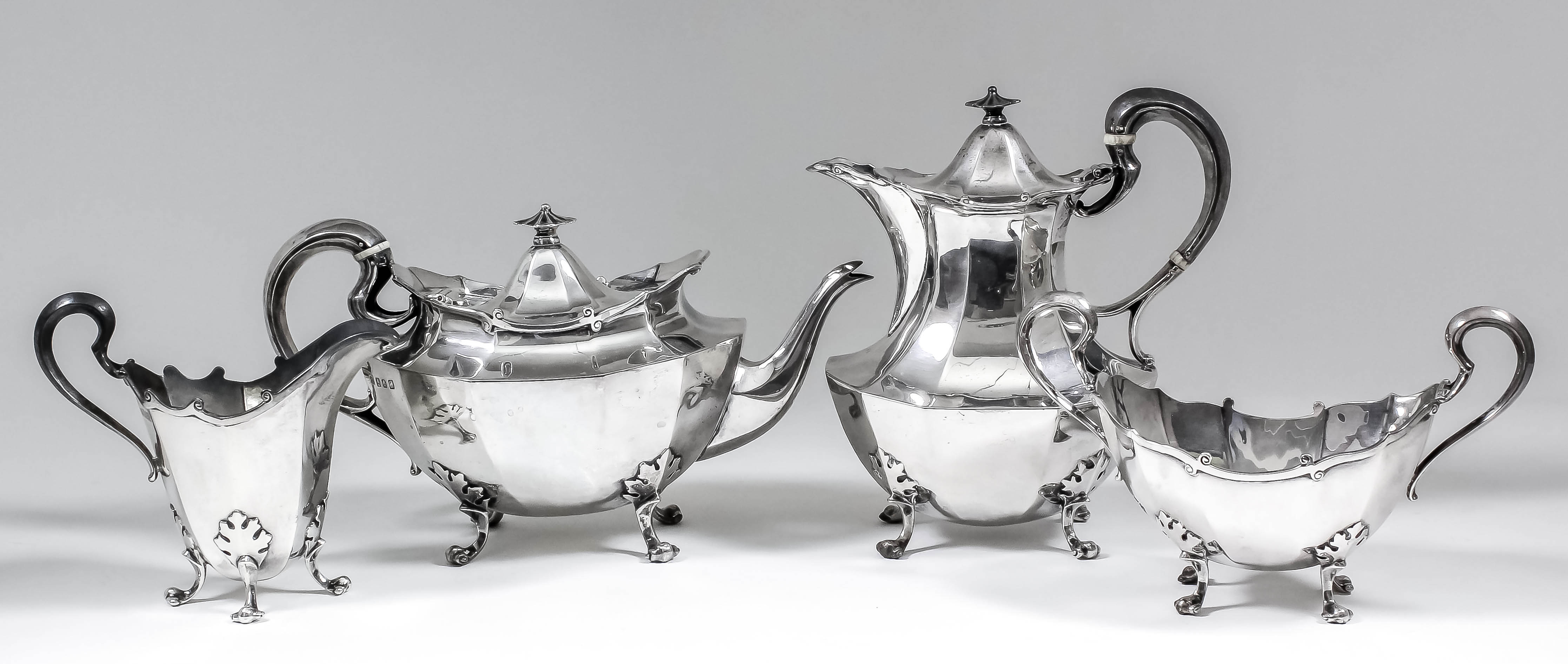 A George V silver oval four piece tea service of panelled form, with scroll mounts, high scroll