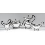 A George V silver oval four piece tea service of panelled form, with scroll mounts, high scroll