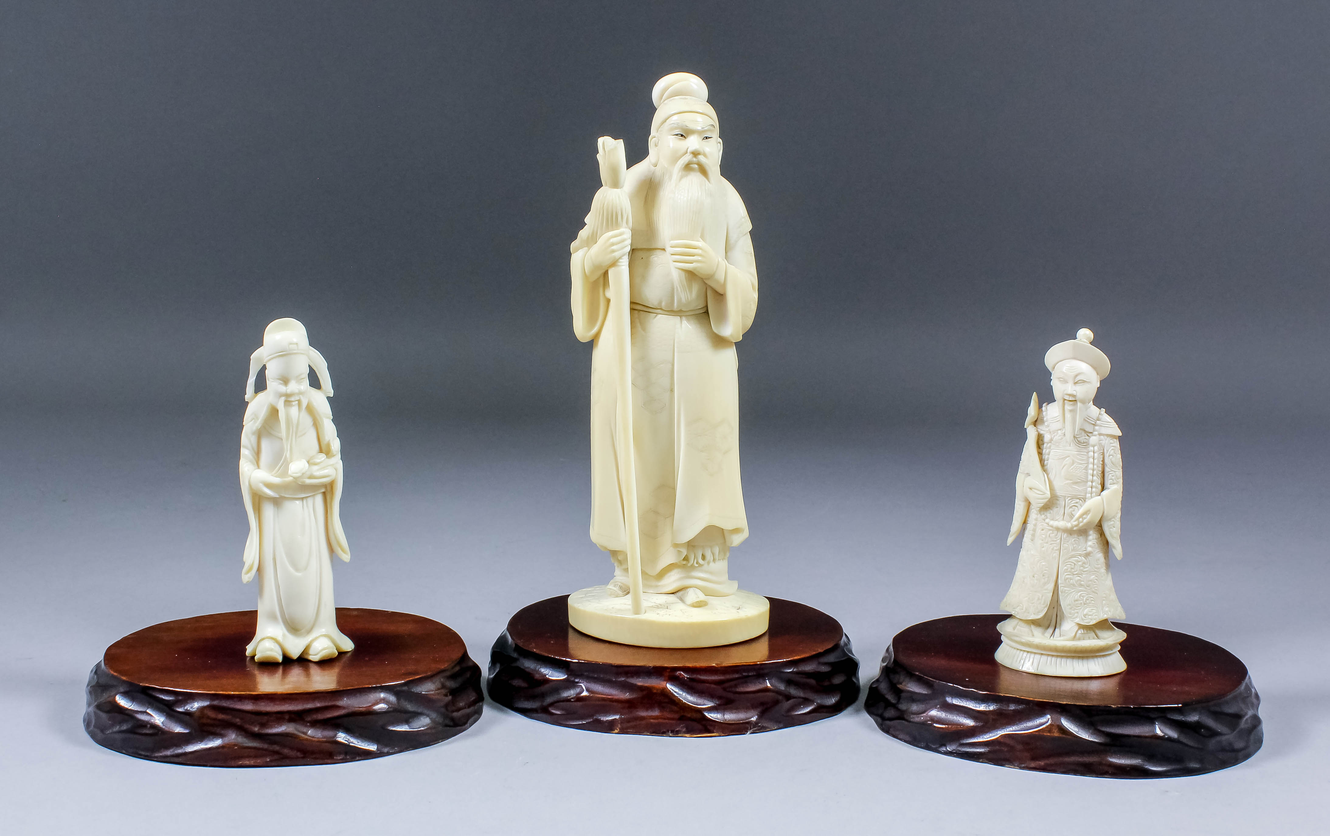A Japanese carved ivory Okimono of a standing bearded sage, his left hand raised to his beard,