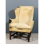 An 18th Century mahogany framed wing back easy chair upholstered in calico, on square chamfered