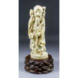 A Japanese large carved ivory Okimono of a standing bearded sage wearing cap and long flowing robes,