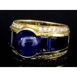 A modern 15ct mounted sapphire and diamond ring, the cabochon cut sapphire of approximately 6ct