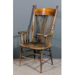 A late 19th Century Armerican oak stick back armchair with curved crest rail, dished seat and on