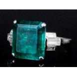 A 1920's silvery coloured metal mounted emerald and diamond ring, the square cut emerald of