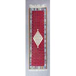 An Eastern Khelim runner woven in colours with a central bold lozenge-shaped medallion, filled