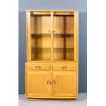 A modern Ercol blonde elm "Windsor" display cabinet, the upper part fitted two plate glass