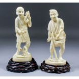 Two Japanese carved ivory Okimono of standing peasant farmers, one holding a scythe in his right and