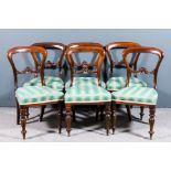 A set of six Victorian mahogany balloon back dining chairs with plain crest rails, scroll carved