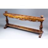 A South-East Asian hardwood kris stand to hold nine kris, the upper edges carved with a running leaf