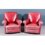 A pair of 1920s scroll back easy chairs with outscrolled arms, re-upholstered in faded red hide