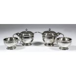 A George V silver circular four piece condiment set with moulded rims and engraved with band of