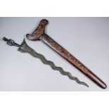 A composite Indonesian Kris with 14ins serpentine blade, hilt in the form of a stylised man,