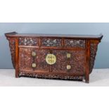 A Chinese rosewood sideboard with flush panelled top and scroll ends, the front carved with