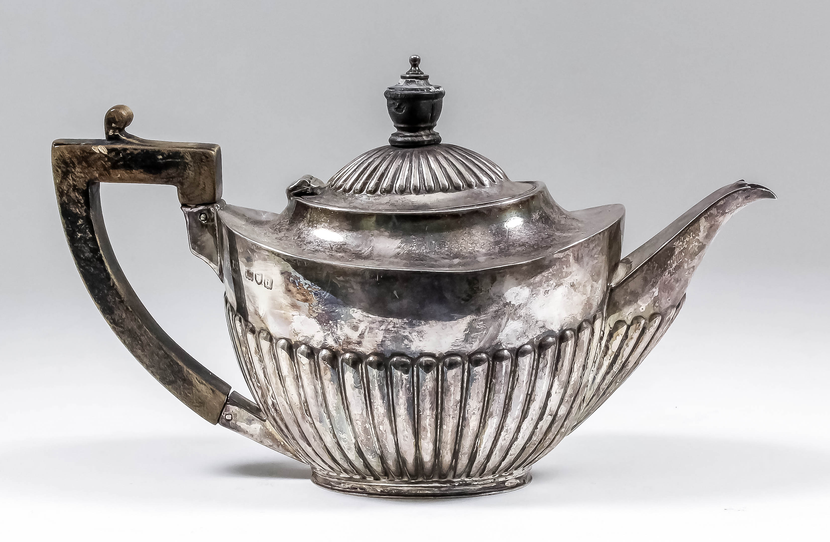 An Edward VII silver oval teapot with part reeded lid and body, ebonsied angular handle and