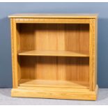 A modern Ercol blonde elm open front bookcase with two adjustable shelves, on plinth base, 38ins