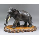 A Japanese textured bronze of an elephant with ivory tusks, 8.5ins (21.5cm) high, signed within