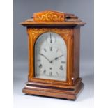 A late 19th/early 20th Century German mahogany cased mantel clock, the arched silvered dial with