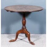 A George III mahogany circular tripod table with one piece top, on turned central column and